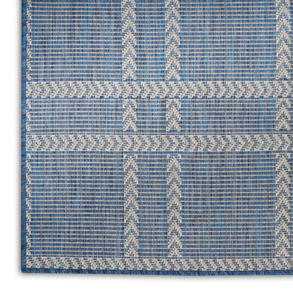 Blue flatwoven rug with cream geometric lattice borders and chevron accents; modern rectangular decor.