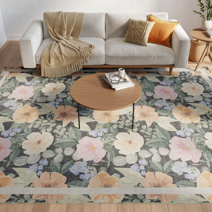 8' x 10' farmhouse floral rug in a living room with a light gray sofa, beige throw, orange cushions, and a round wood coffee table.