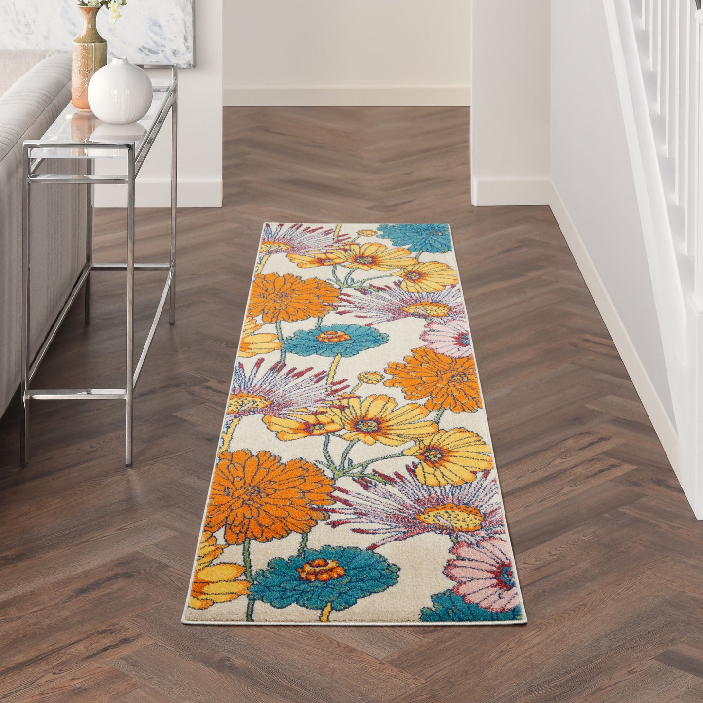 Long rectangular floral runner rug with bright orange, teal and yellow blooms on cream background; modern hallway decor.