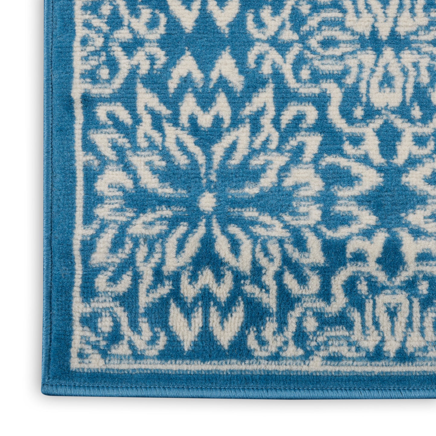 Blue and white patterned bath rug with ornate floral medallion, looped terry texture.