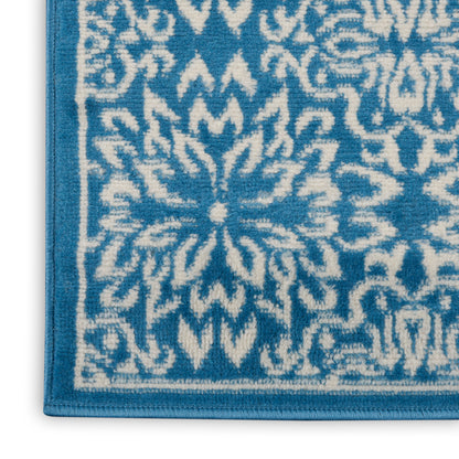 Blue and white patterned bath rug with ornate floral medallion, looped terry texture.