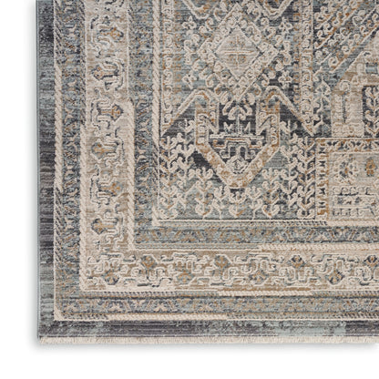 Rectangular distressed vintage-style rug with geometric medallion pattern in blue, ivory and beige.
