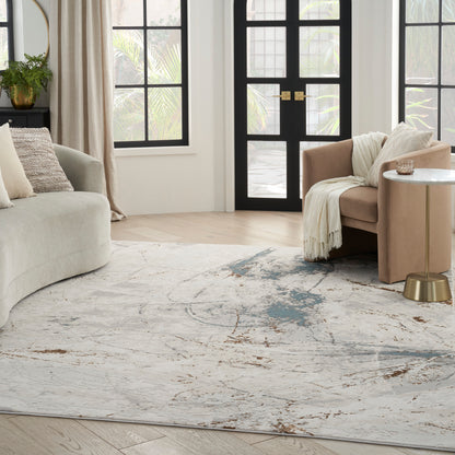 Neutral living room with cream sofa, blush armchair, round marble-top gold side table, abstract rug, black-framed doors.
