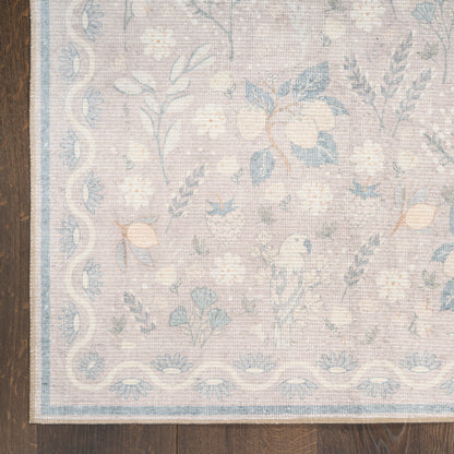 Pastel floral area rug with soft beige background, blue flowers, and a pale blue border on dark wood floor.
