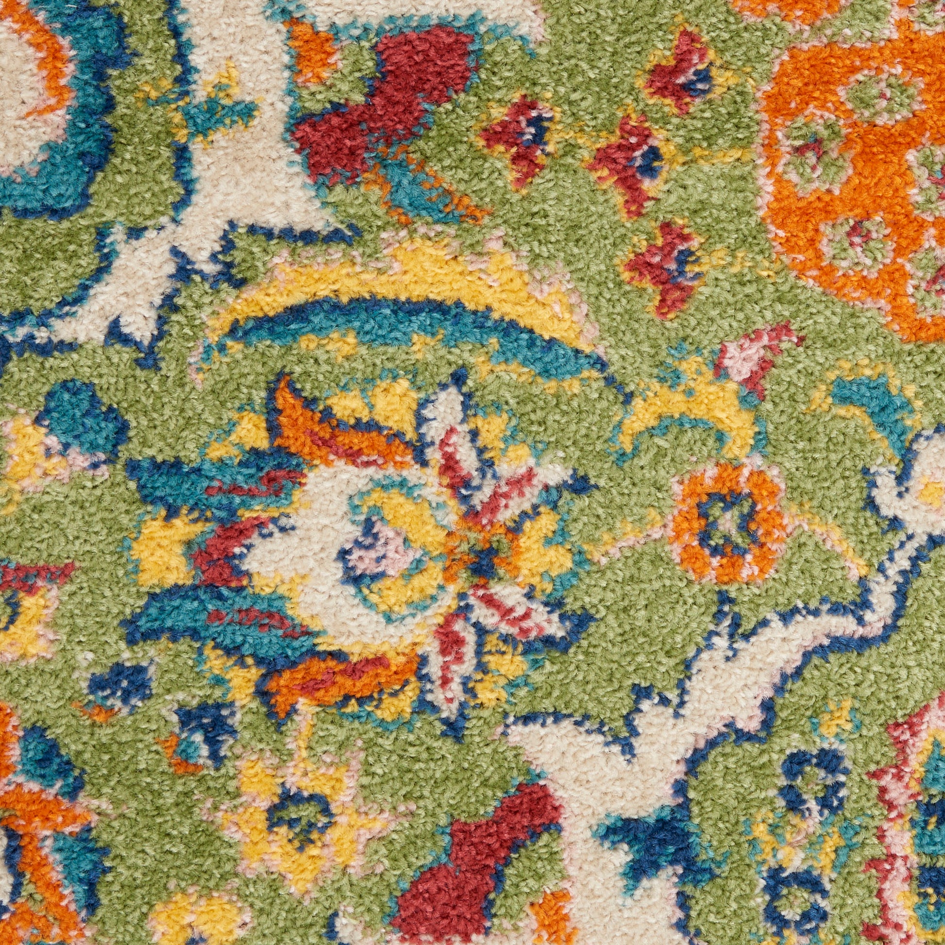 Close-up of a vibrant oriental rug with a green field and multicolor floral motifs in yellow, orange, blue, red and ivory.