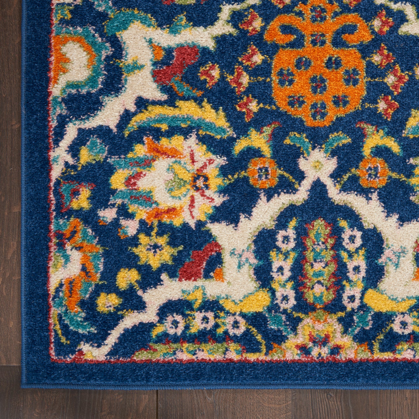Colorful oriental rug with blue field, vibrant floral motifs and orange medallions, bordered in deep blue.