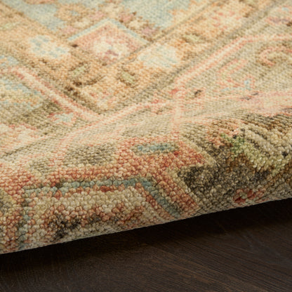 Pastel oriental rug with pink, blue, beige and green geometric motifs; thick plush pile, edge folded over dark wood floor.