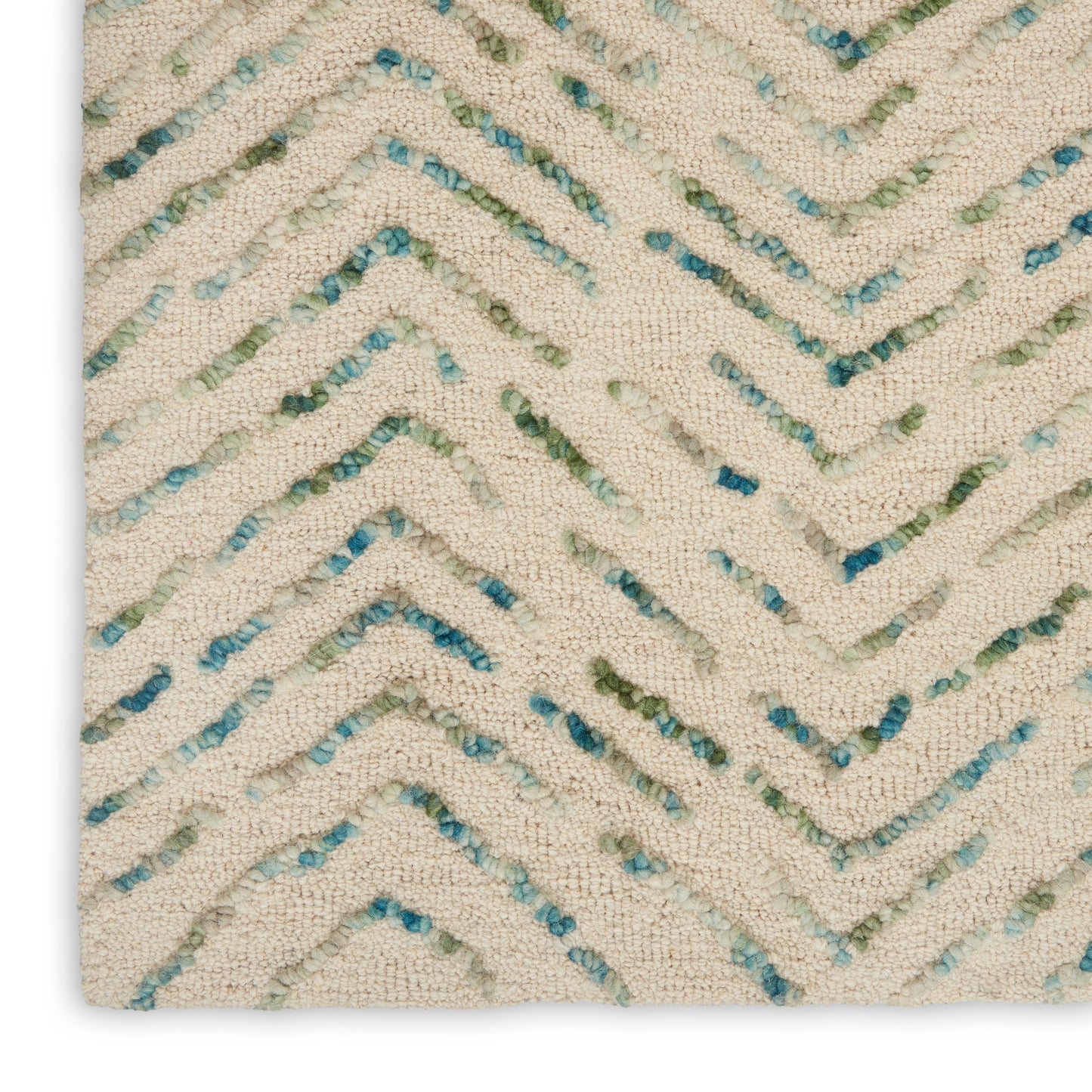 Cream textured rug with blue-green and teal chevron zigzags; looped boucle texture.