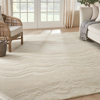Cream-beige area rug with subtle wavy pattern and woven texture in a bright living room.