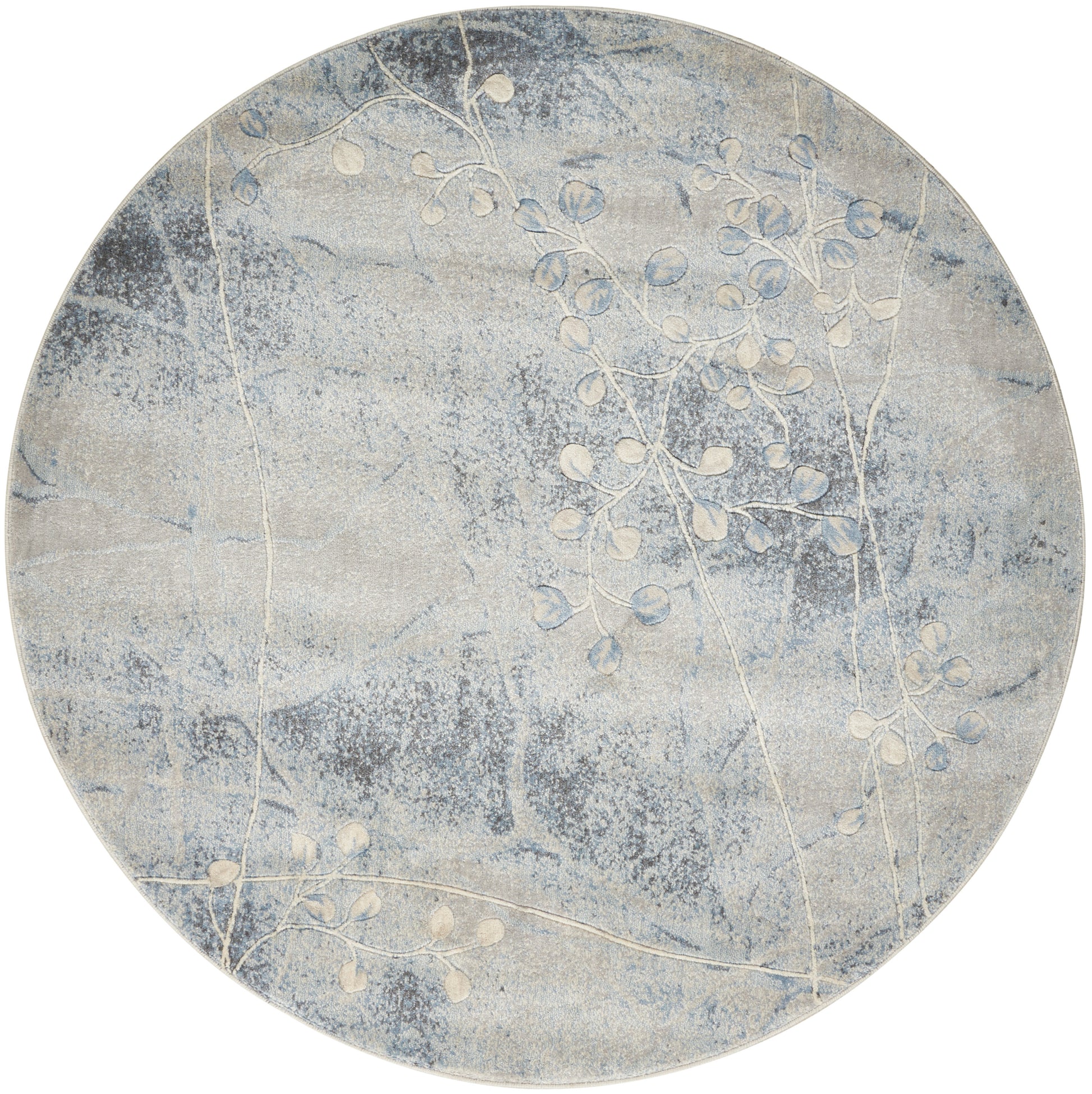 Round blue-gray rug with soft cloud-like texture and white botanical branch pattern.