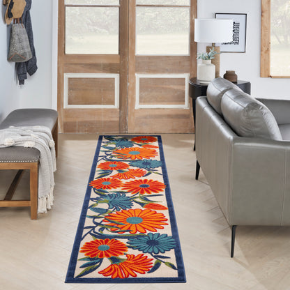 Floral hallway runner rug with bright orange and blue flowers, navy border on light wood floor.