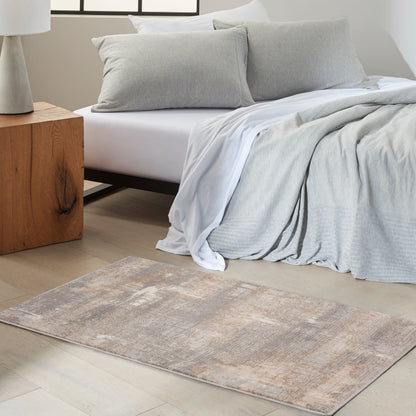 Neutral bedroom with light gray duvet, matching pillows, white sheets, beige-gray rug, and wooden block nightstand.