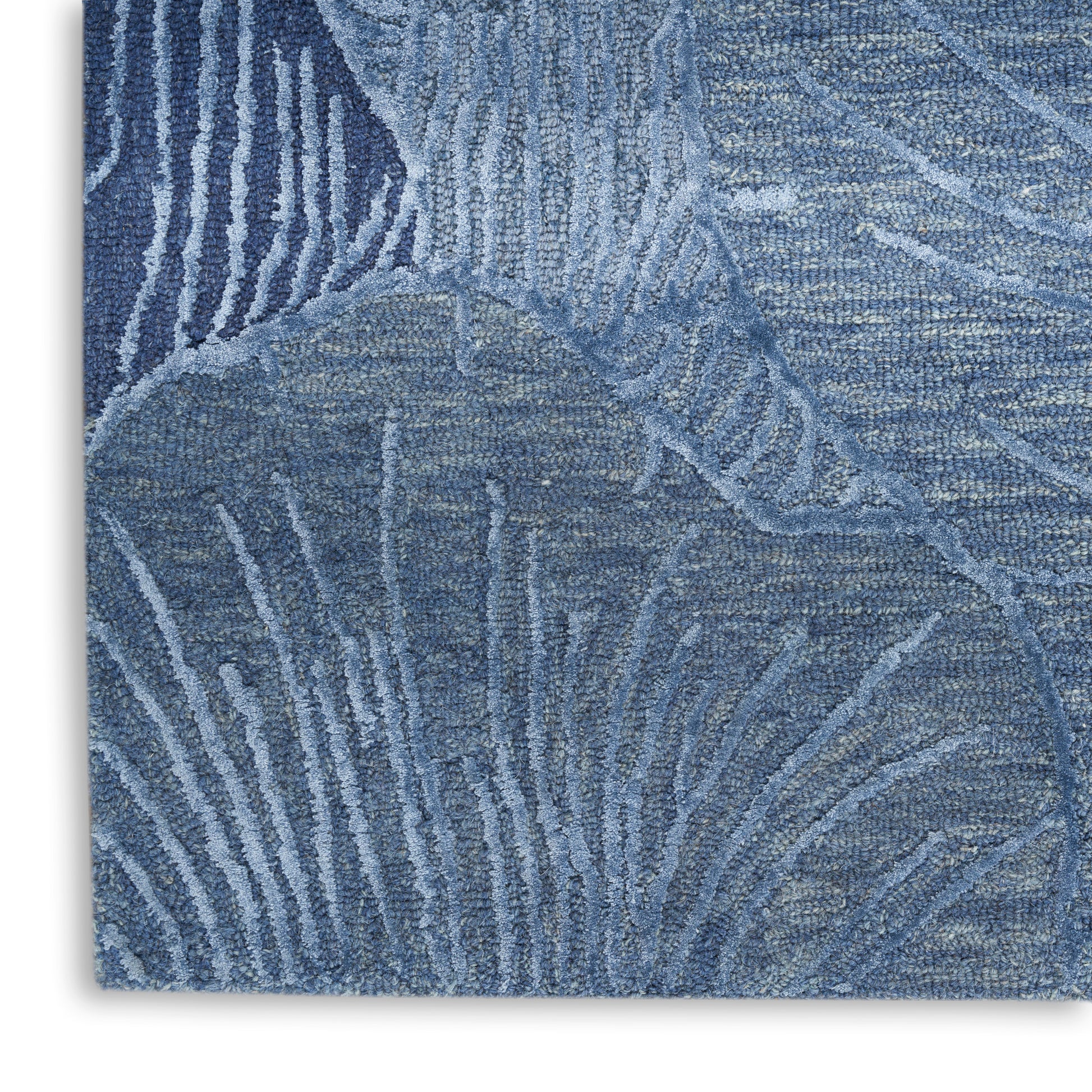 Blue textured rug with abstract leaf motif and soft pile.