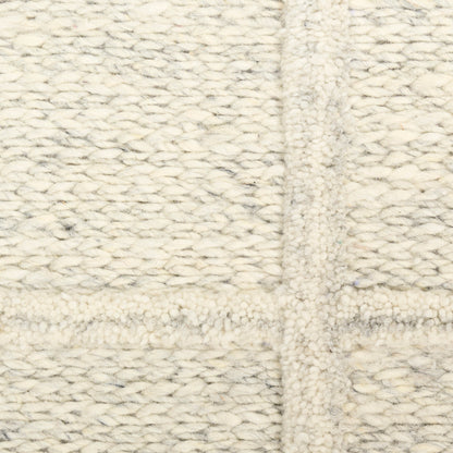 Cream chunky knit throw blanket with thick wool yarn and soft, textured woven stitches.