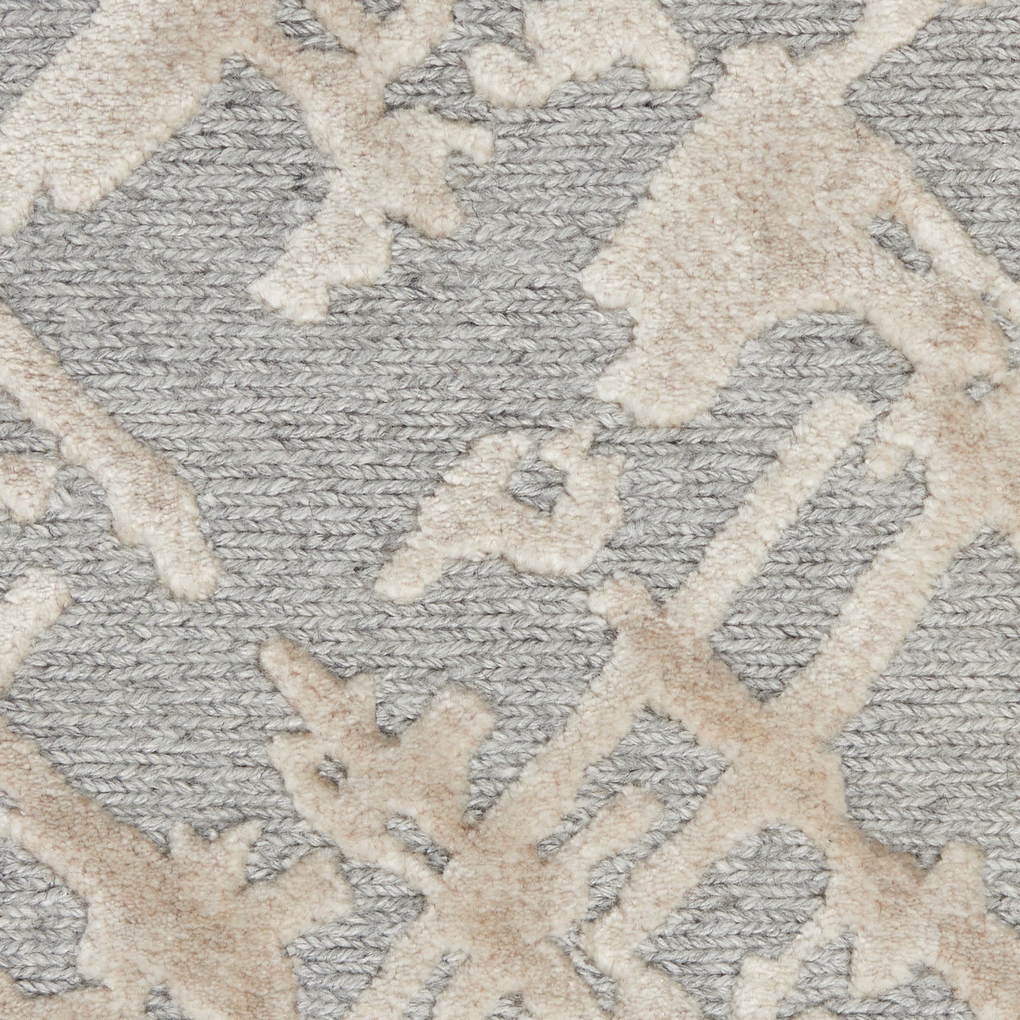 Gray textured rug with cream-beige abstract geometric motif and plush pile.