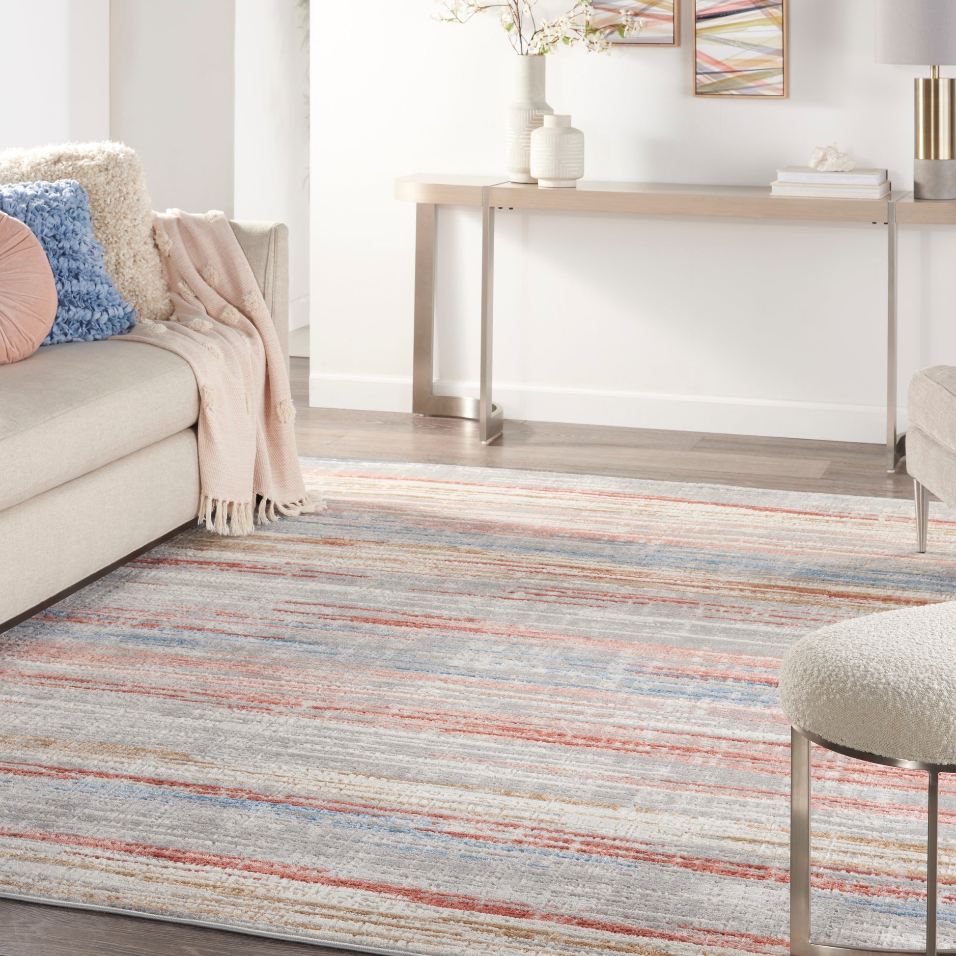 Soft striped area rug with blue, coral, and beige tones; plush texture for a modern living room.