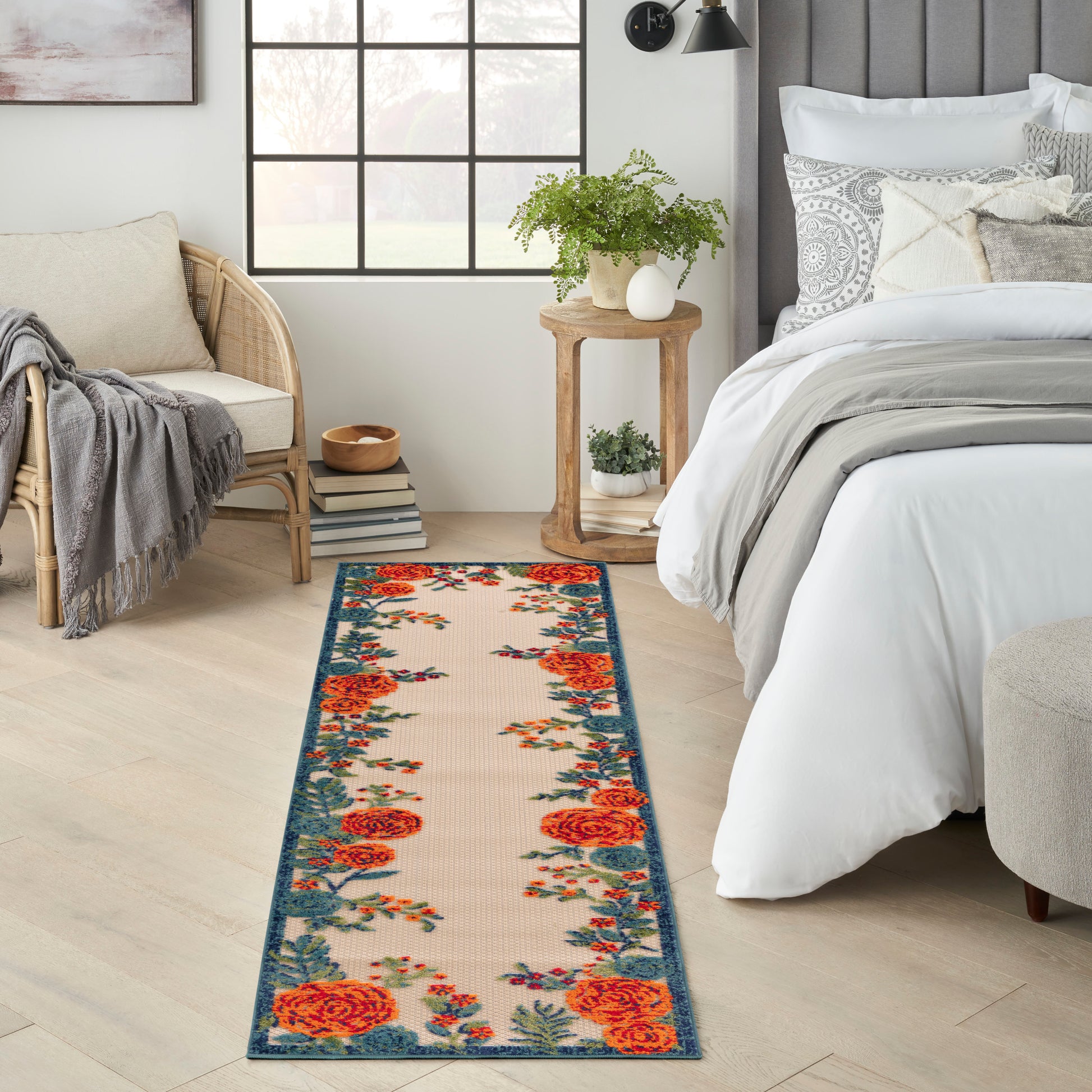 Narrow outdoor runner rug with orange roses on beige, blue border, 8' long.