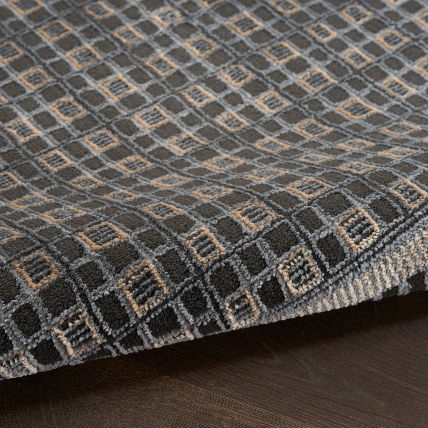 Dark gray rug with tan diamond-grid pattern and soft pile for modern living spaces.