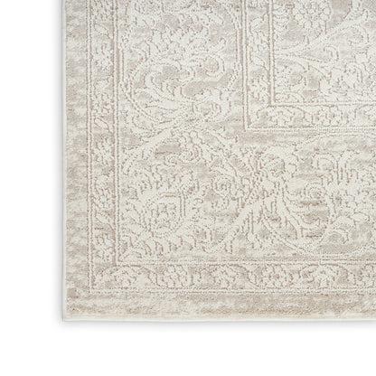 Beige oriental rug with intricate floral border and soft, textured pile in ivory and taupe tones.