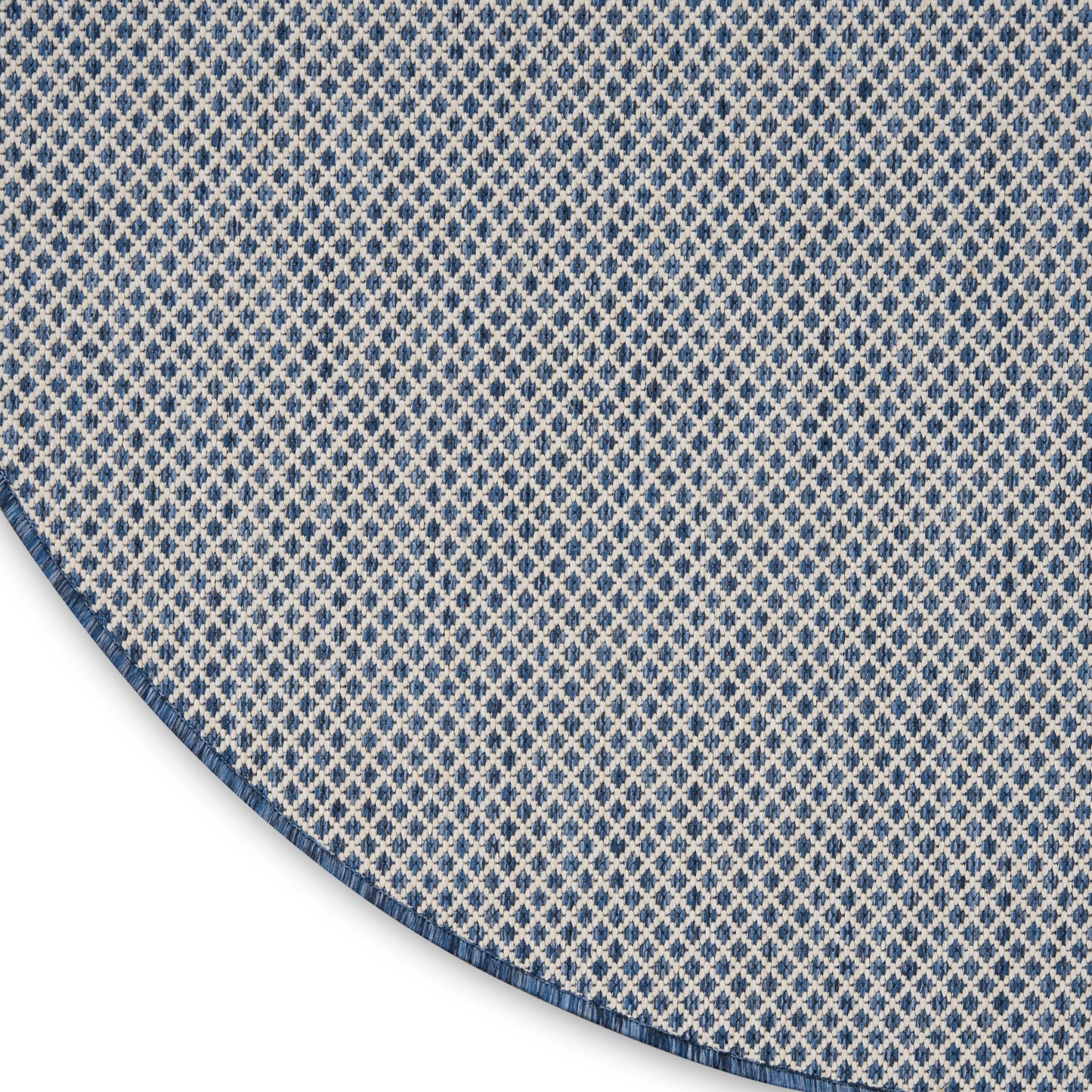 Grey gradient backdrop with a blue-and-white diamond-pattern fabric edge visible at bottom-right.