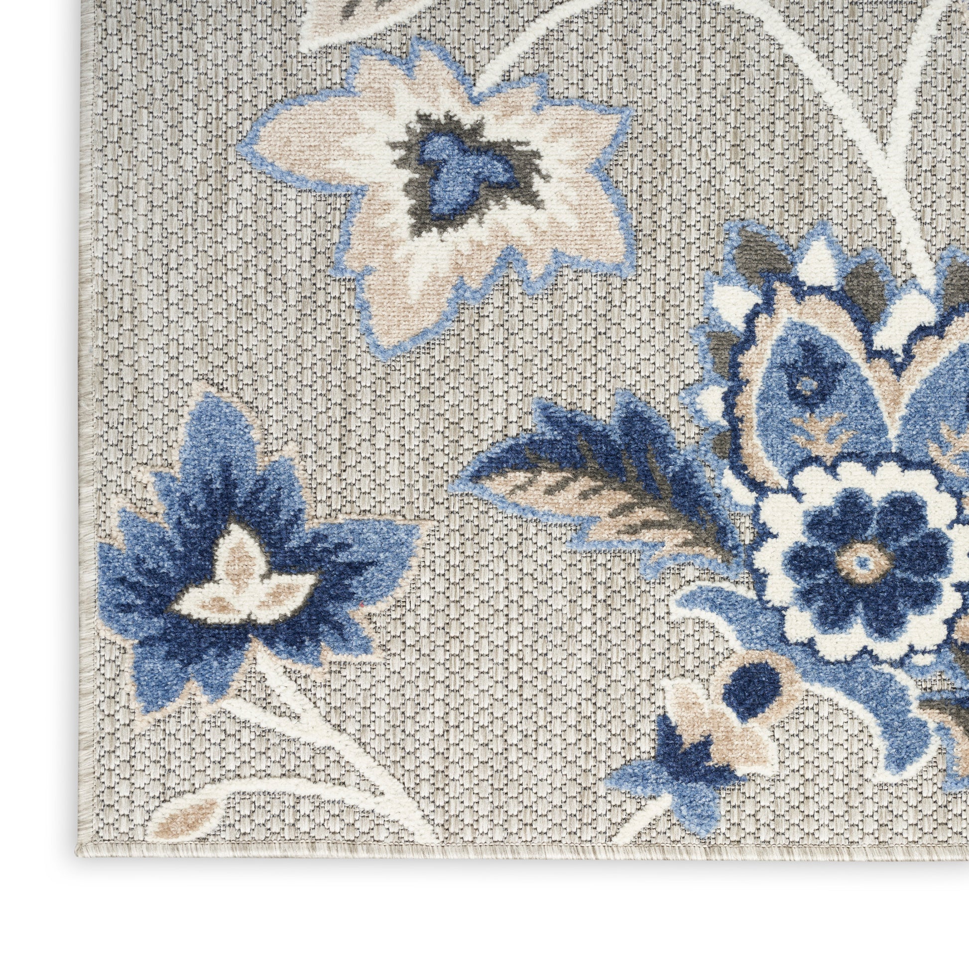 Beige woven rug with blue floral damask pattern, large blossoms and scrolling vines on a light textured background.