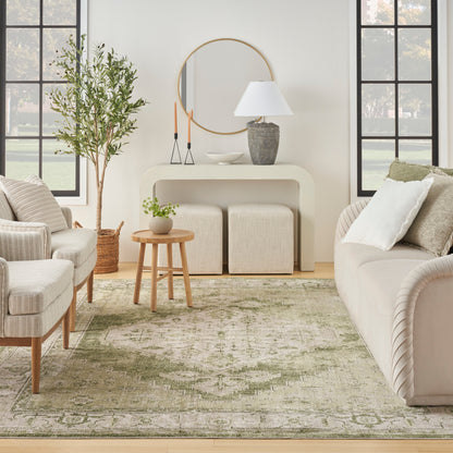 Neutral living room with cream sofas, round mirror, curved cream console, green patterned rug, and wooden round coffee table.