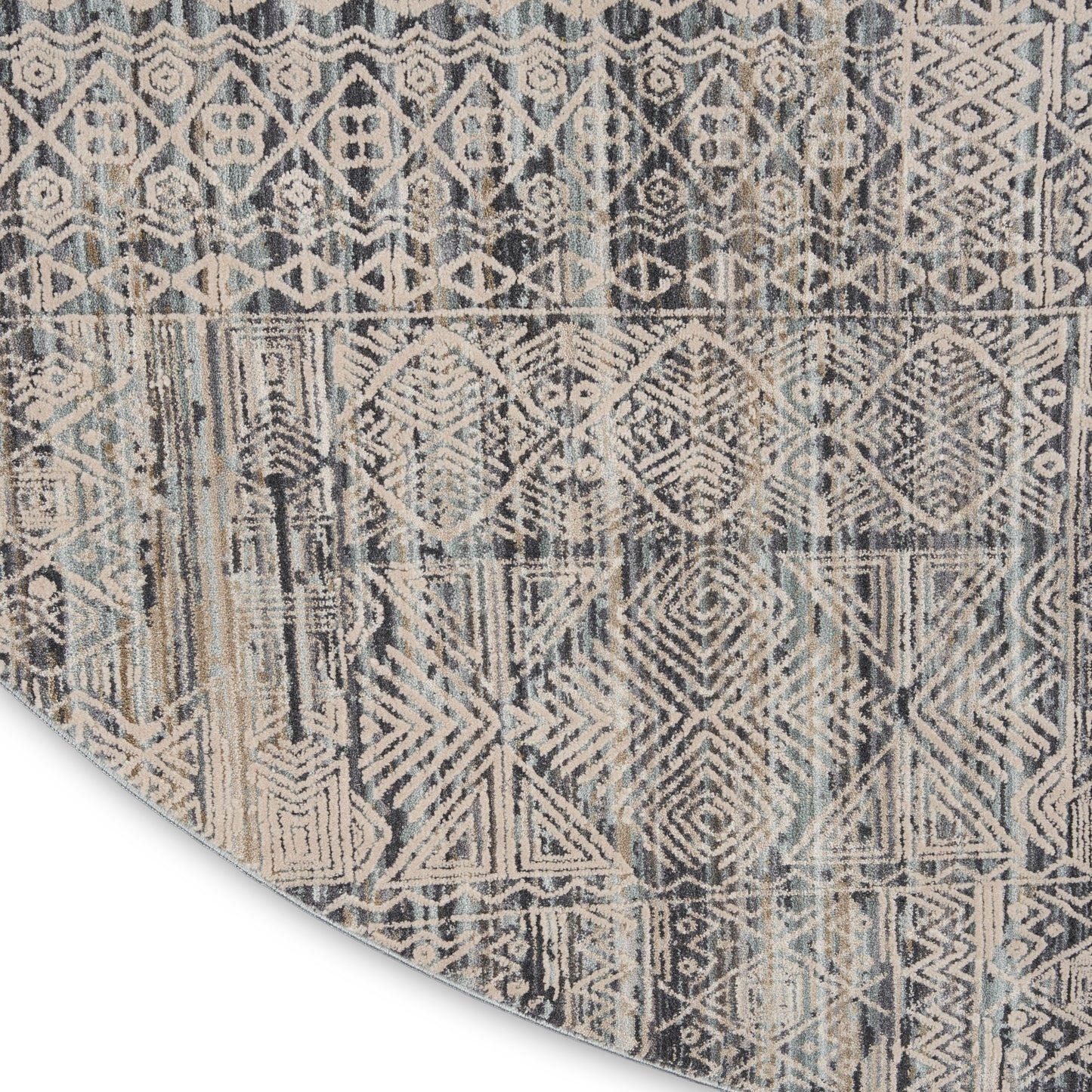Muted blue, beige and gray geometric rug with aztec/tribal diamonds and chevrons; folded corner visible.