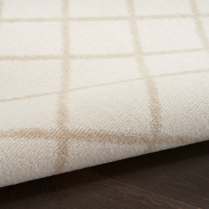 Cream rug with a light tan grid pattern, folded over a dark wooden surface