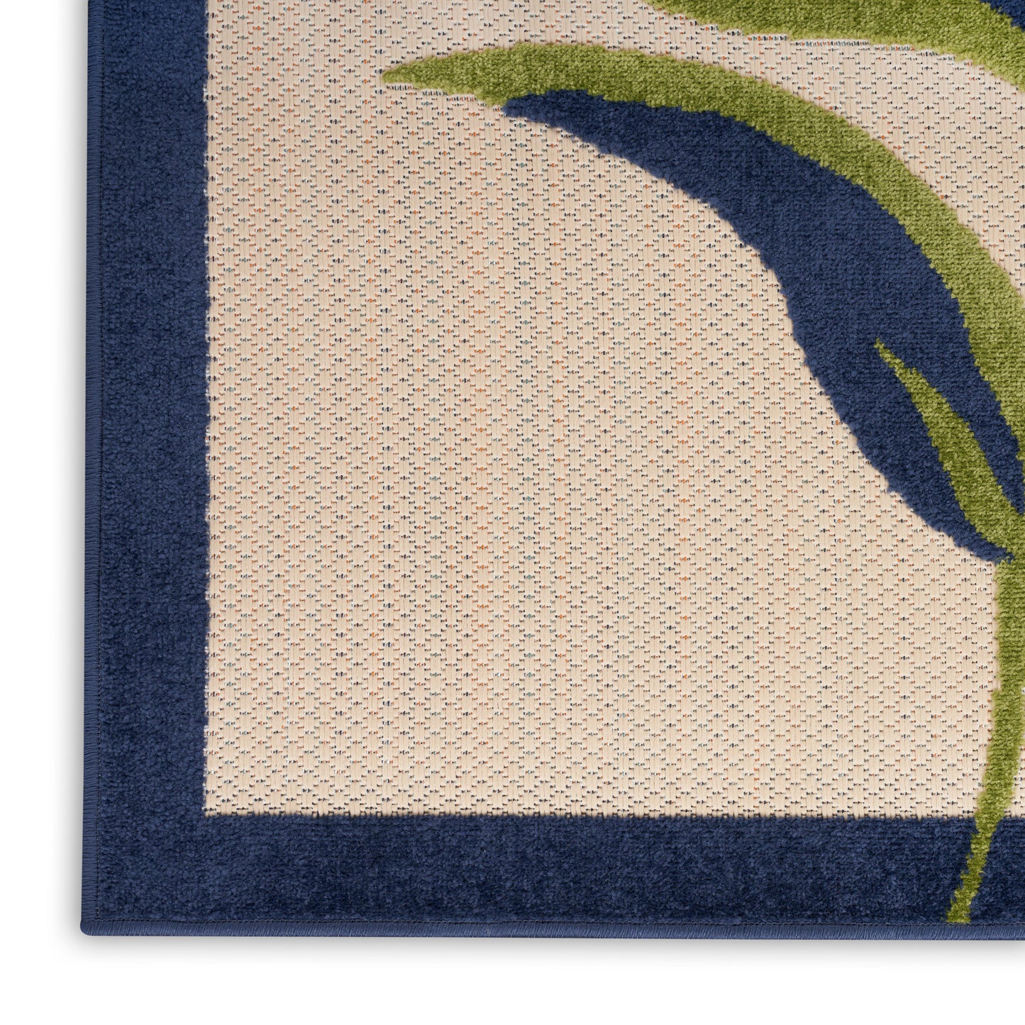 Beige looped-pile rug with navy border and green curved leaf motif; modern botanical design.