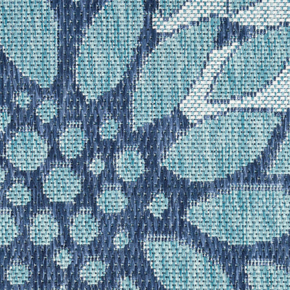 Geometric rug in blue and teal with diamond and circular motifs; woven textile.