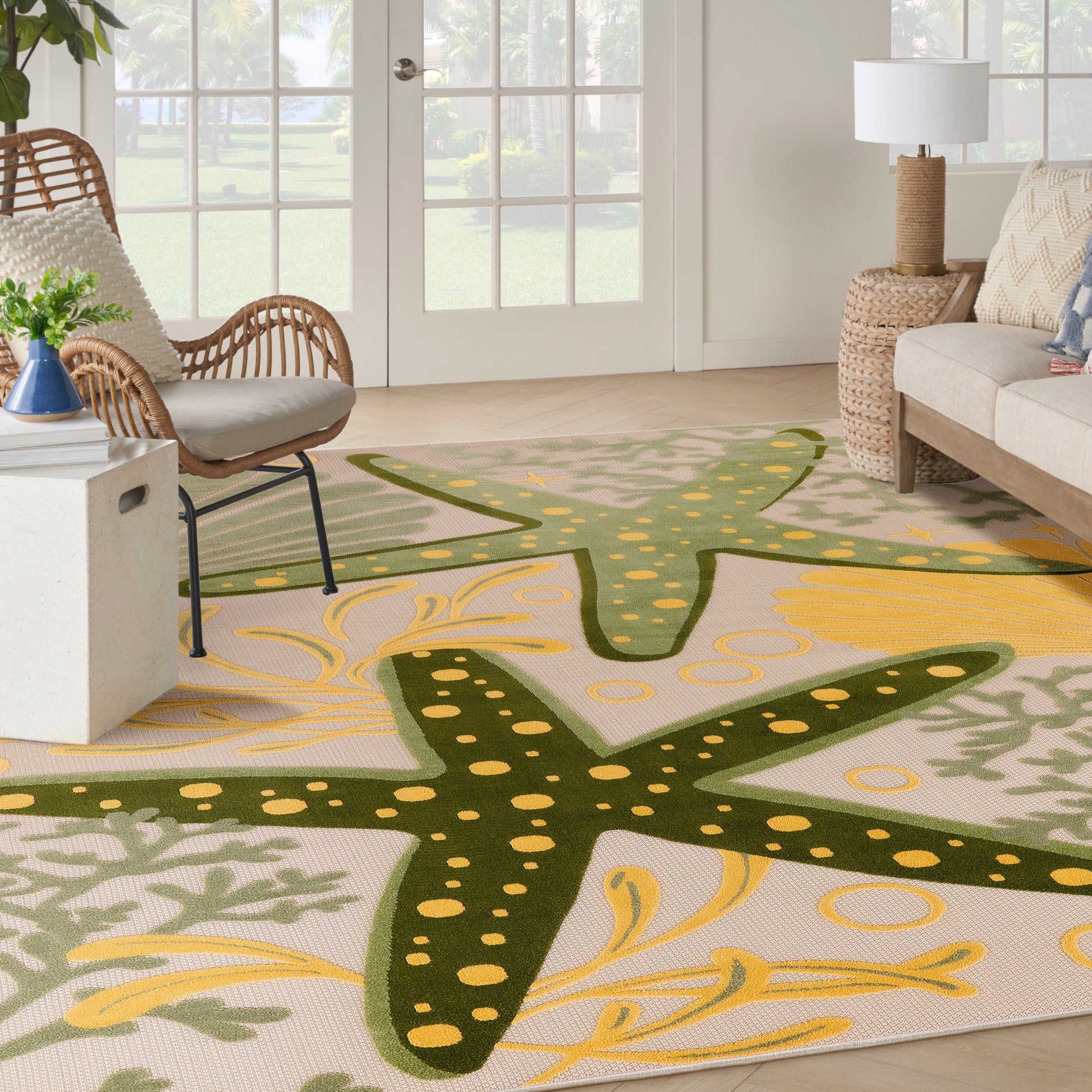 Outdoor coastal rug featuring large starfish motifs in dark green on a beige background with yellow accents.