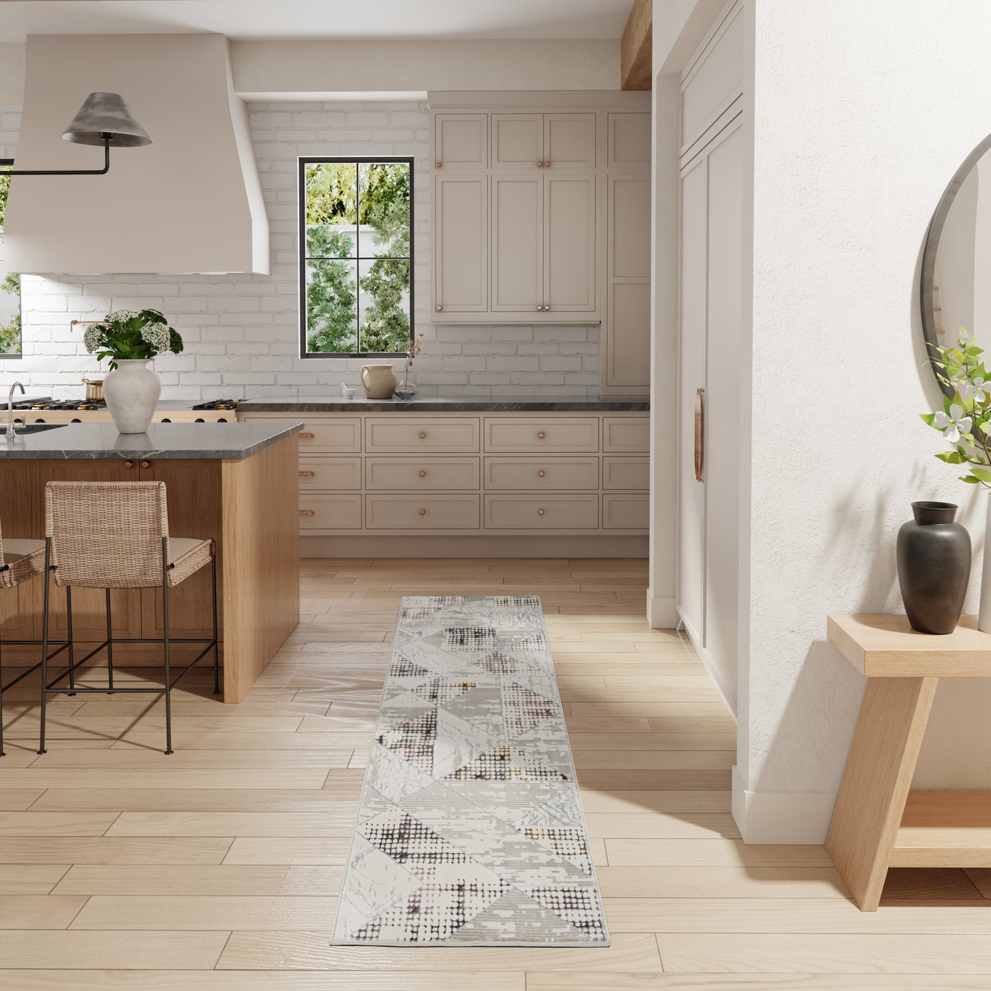 Bright modern farmhouse kitchen with white cabinets, light wood floors, island, grey geometric runner rug & metal bar stools.