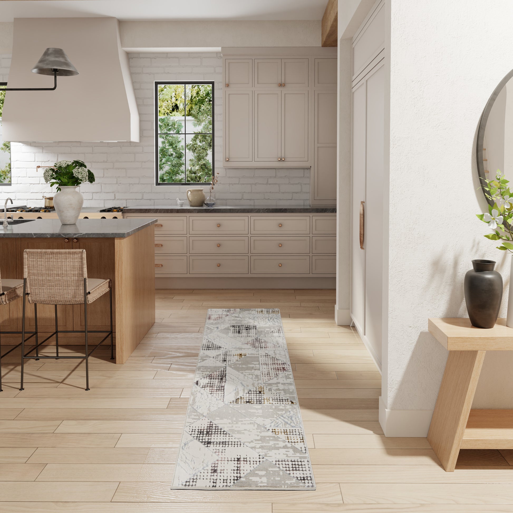 Bright modern farmhouse kitchen with white cabinets, light wood floors, island, grey geometric runner rug & metal bar stools.