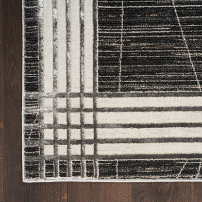 Geometric area rug, 9' x 12', with a black, white and gray grid pattern and a cream border on a dark wood floor.