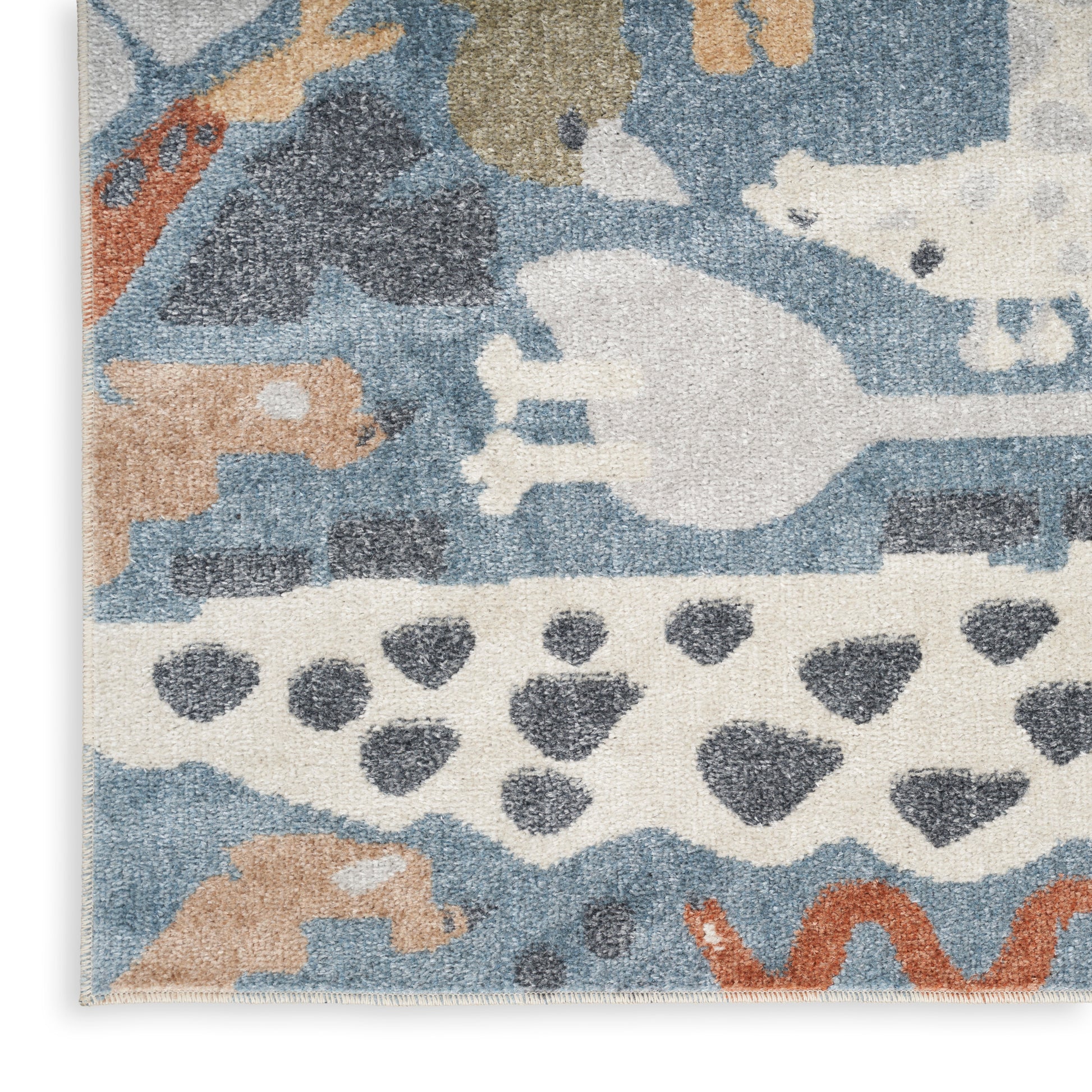 Abstract blue, tan and white woven area rug with animal silhouettes, wavy bands and dot motifs.