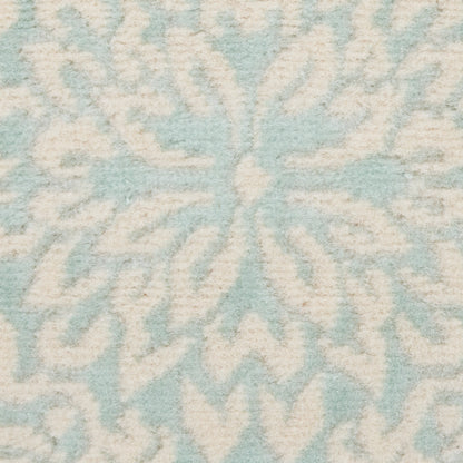 Soft light-blue and ivory tufted rug featuring a large snowflake/starburst motif.