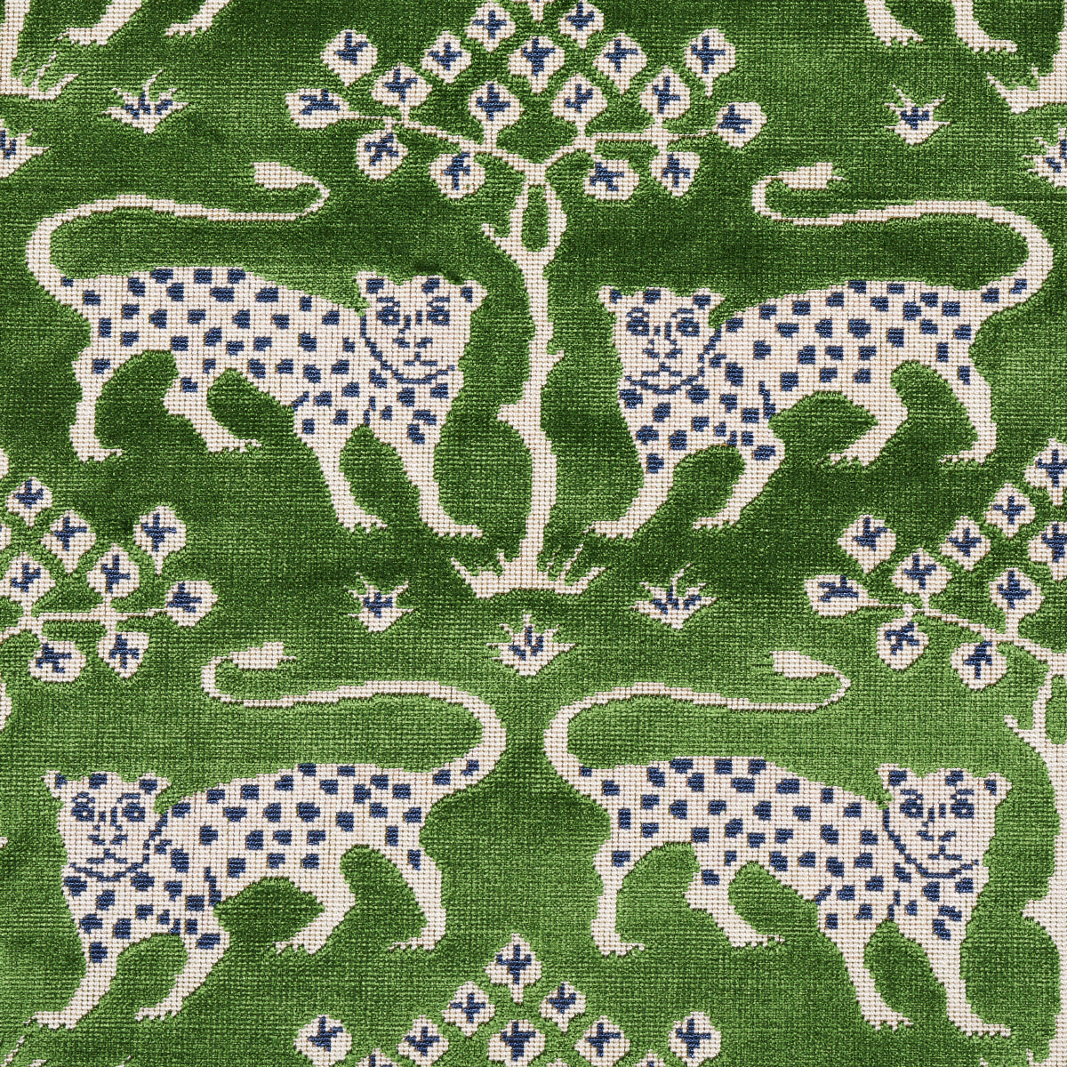 Green textile with a repeating pattern of white leopards with blue spots and a central stylized tree.