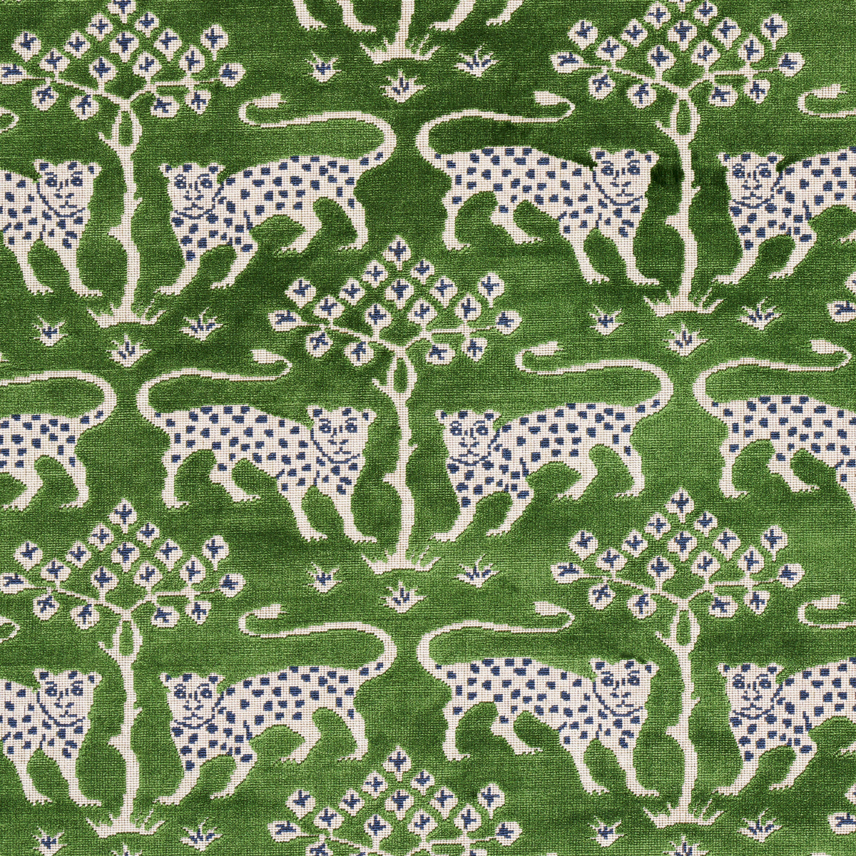 Green fabric featuring white leopards with blue spots and stylized trees in a repeating nature motif.