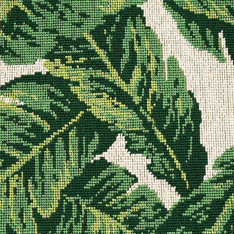 Close-up of green tropical leaf-print fabric; woven texture with dark and light greens on tan background.