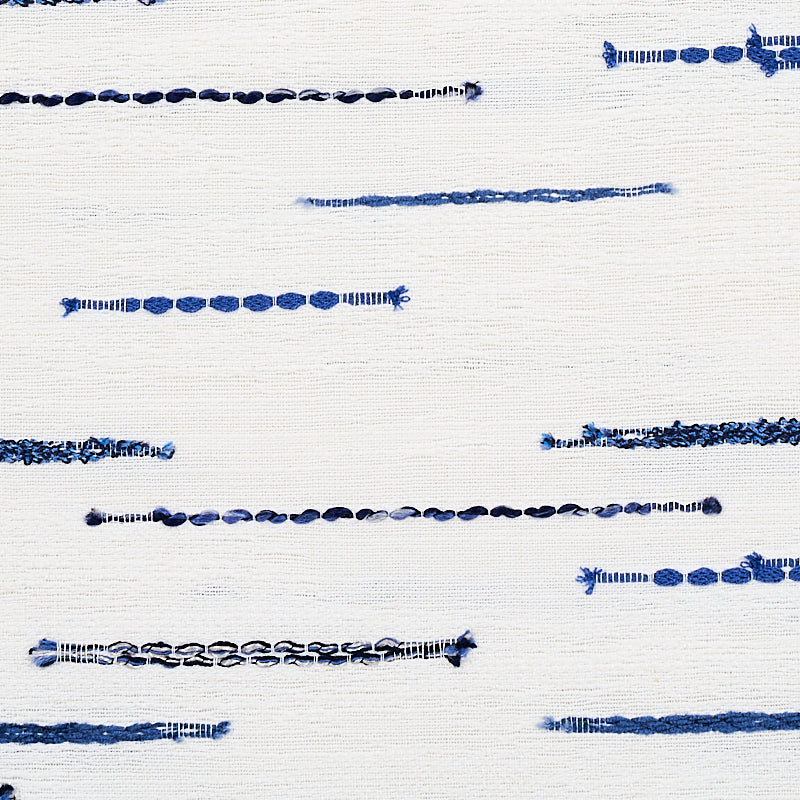 White fabric with scattered horizontal blue stitching lines, denim-inspired embroidery for decorative detail.