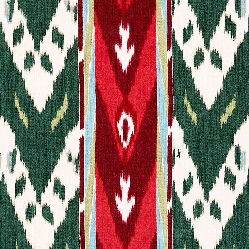 Ikat-inspired geometric textile with green panels, white diamonds, and a red vertical central stripe edged in blue and beige.