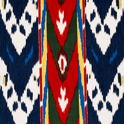 Ikat-inspired woven textile with navy blue and white geometric panels, a red central stripe with green diamonds, and yellow edging.