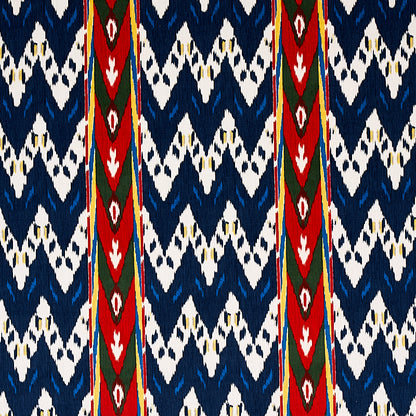 Ikat-inspired navy and white textile with bold red vertical stripes and green diamond accents; versatile fabric.