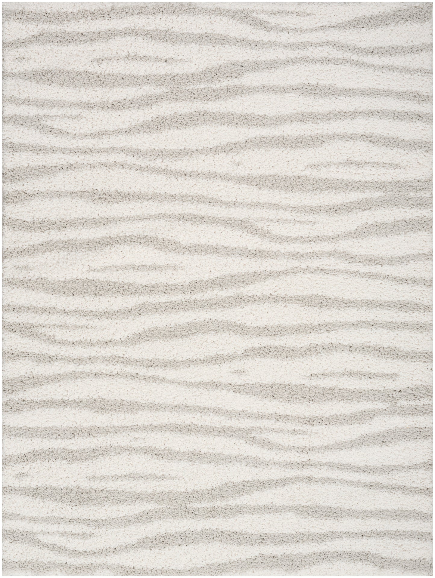 Beige plush rug with cream and taupe wavy stripes resembling sand dunes and a soft texture.