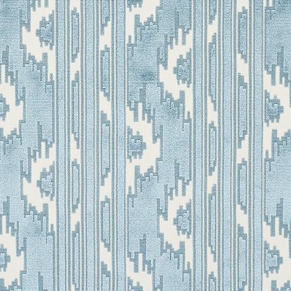 Blue and white ikat-inspired fabric with vertical zigzag stripes and geometric motifs.