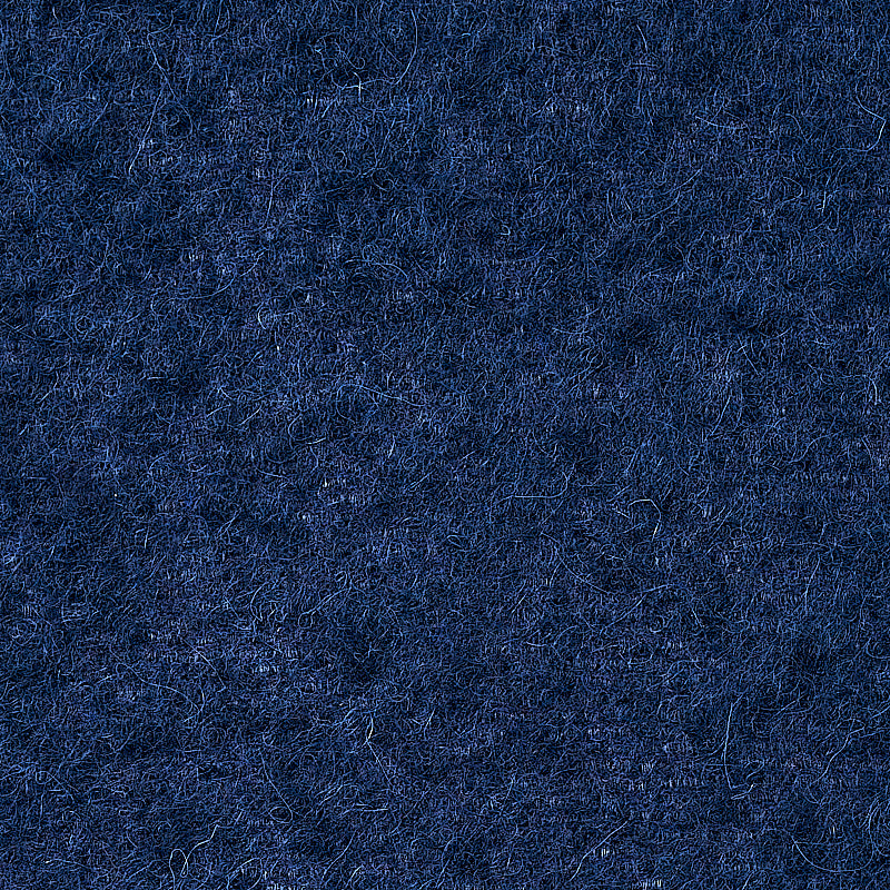 Close-up of navy blue wool felt texture with fuzzy fibers.