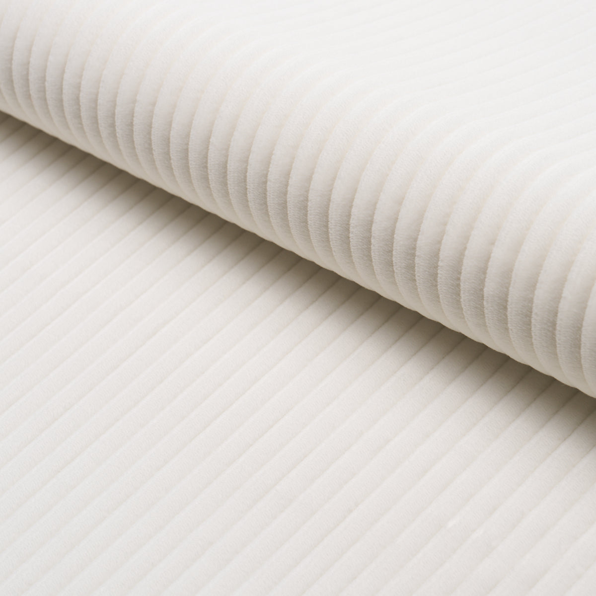 Cream-white ribbed fabric roll with soft corduroy-like texture; versatile for upholstery or apparel.