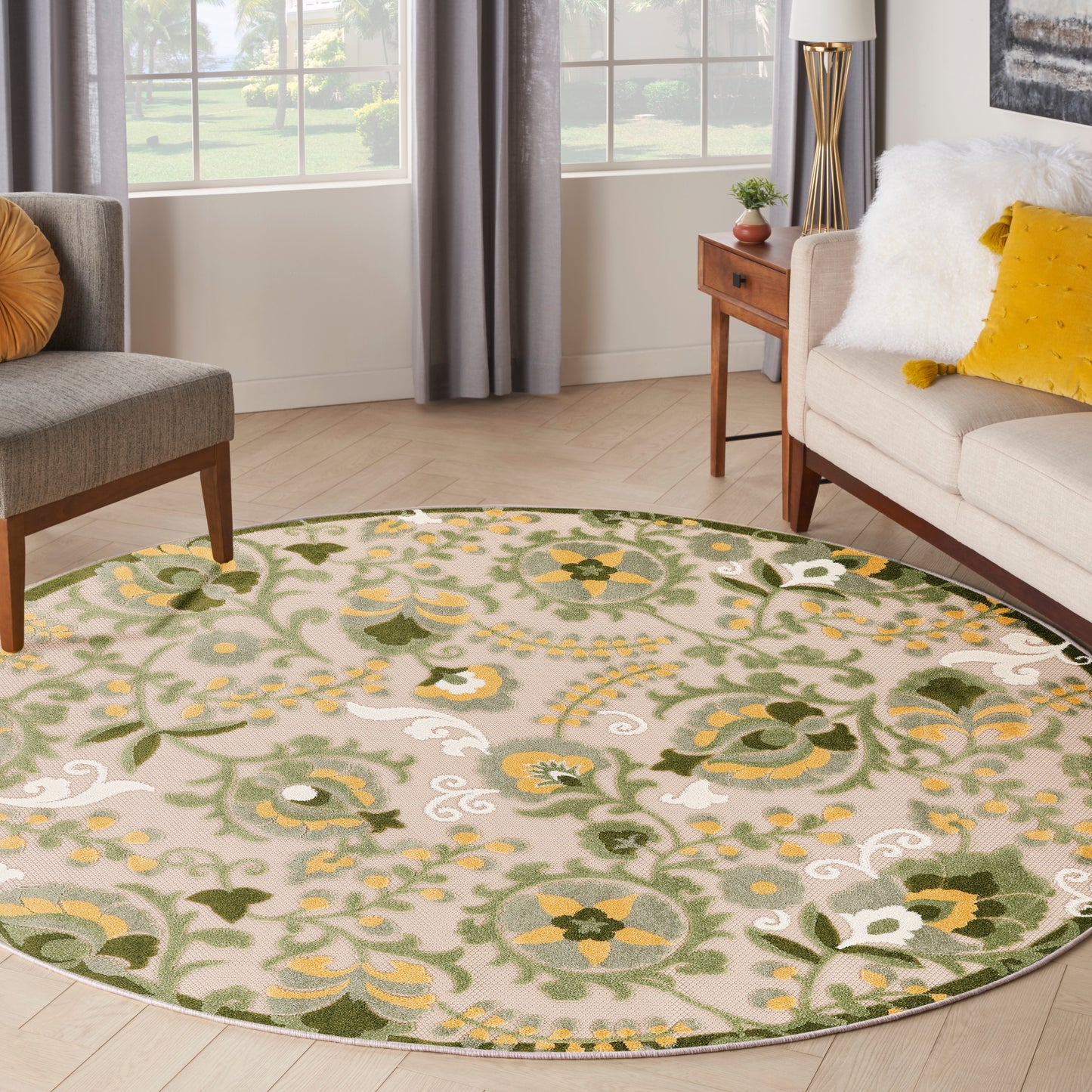 Round floral outdoor area rug in green, yellow & beige; visible in an outdoor seating area.