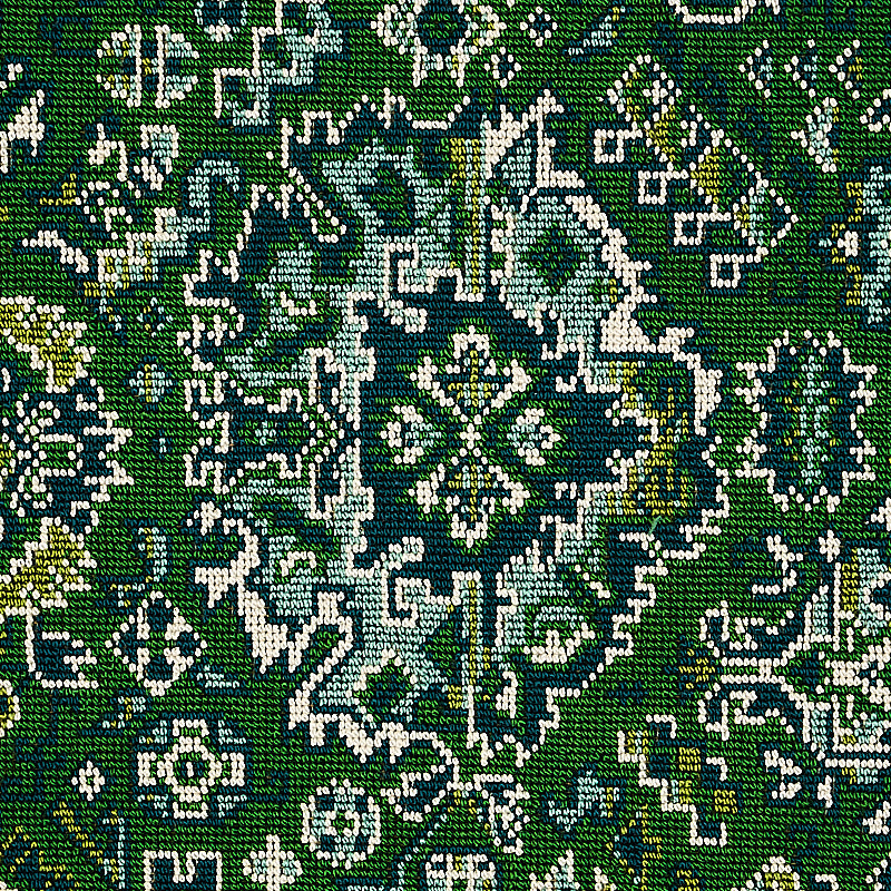Green woven rug with white and blue ornate medallion pattern and oriental floral motif.