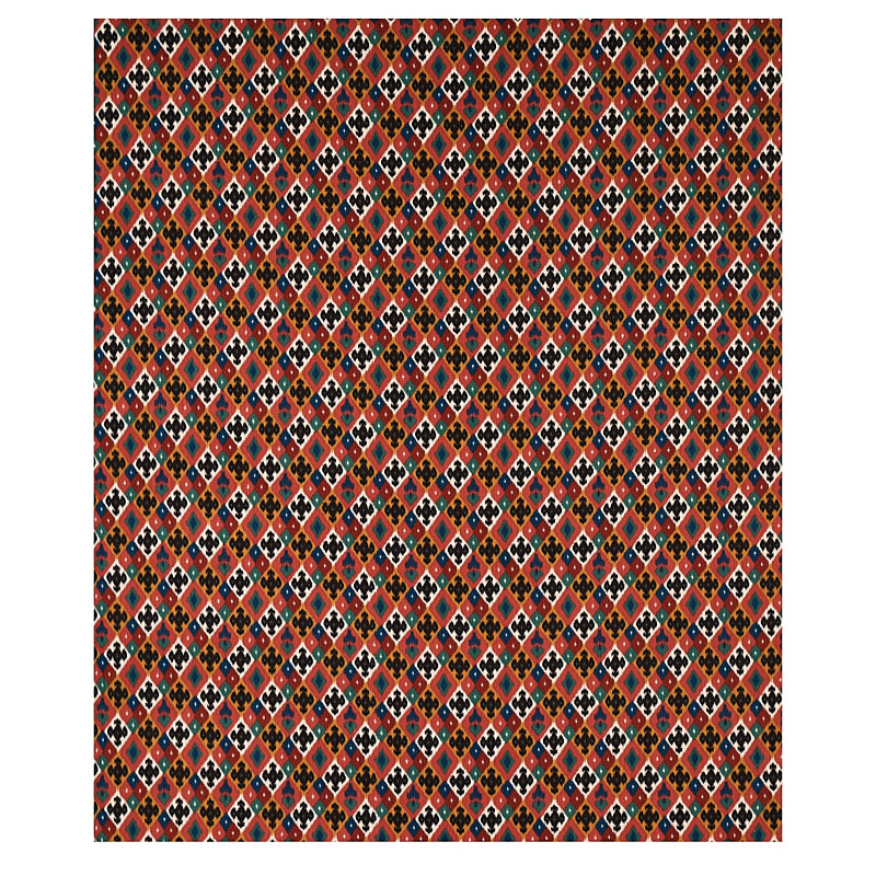 Geometric diamond pattern fabric in red, black, orange, blue and white; dense tribal textile for upholstery or clothing.